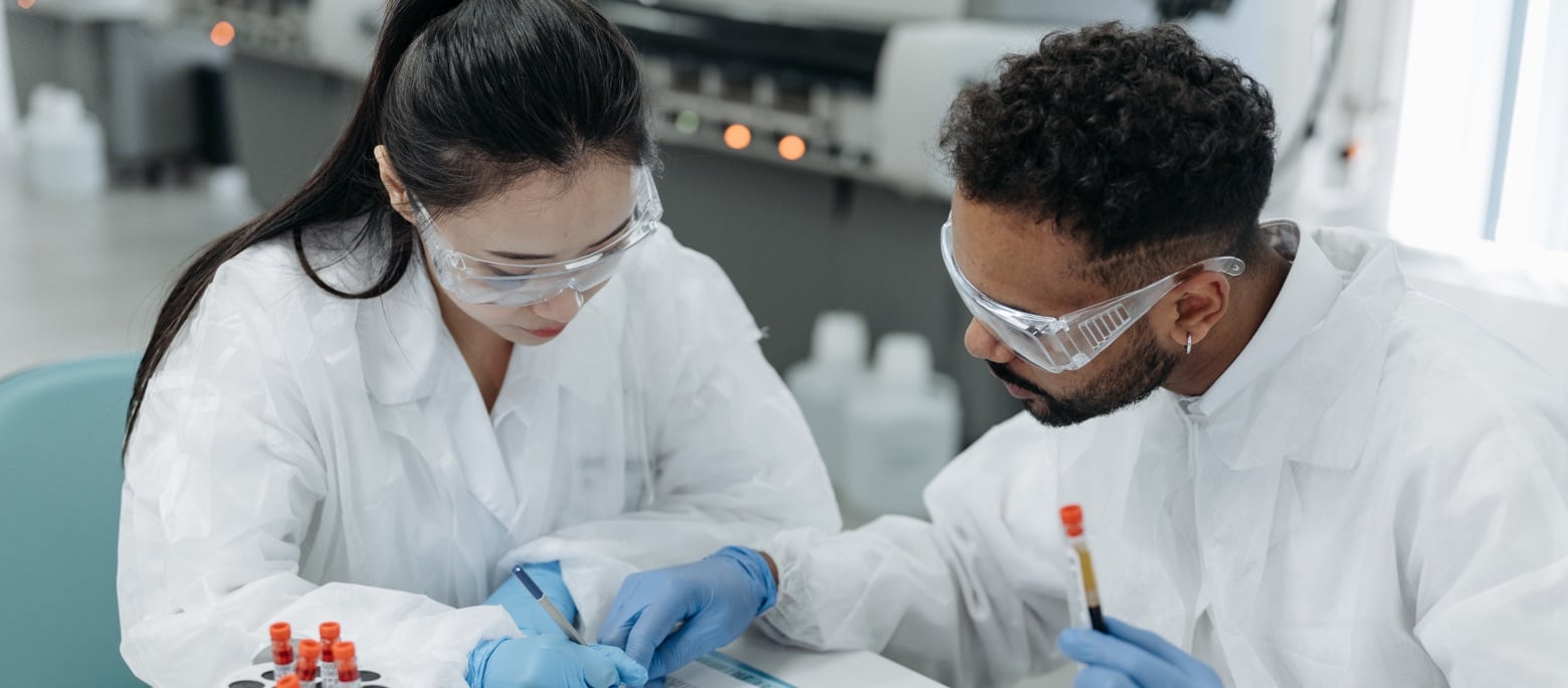 stock image of scientists in lab coats and gloves
